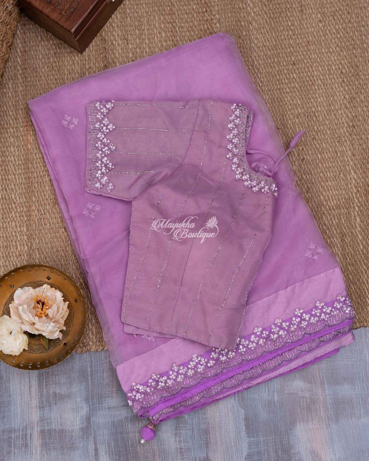 A lovely lilac organza beads work saree is all that you need to woo the eyes. A subtle Lilac foundation is adorned with sequins work butta embraced into a self border carrying sequin-bead work for an absolute delight. A self blouse with sequin-bead work on the neck and hands is accompanied. Purple Organza Pre-draped Saree For Diwali, Unstitched Purple Pre-draped Saree With Dori Work, Purple Embroidered Cotton Silk Dupatta, Purple Chanderi Traditional Wear With Dori Work, Fitted Lavender Blouse Piece For Festive Occasion, Festive Fitted Lavender Blouse Piece, Purple Cotton Silk Set With Cutdana, Lavender Saree With Zari Work, Lavender Saree Set With Zari Work