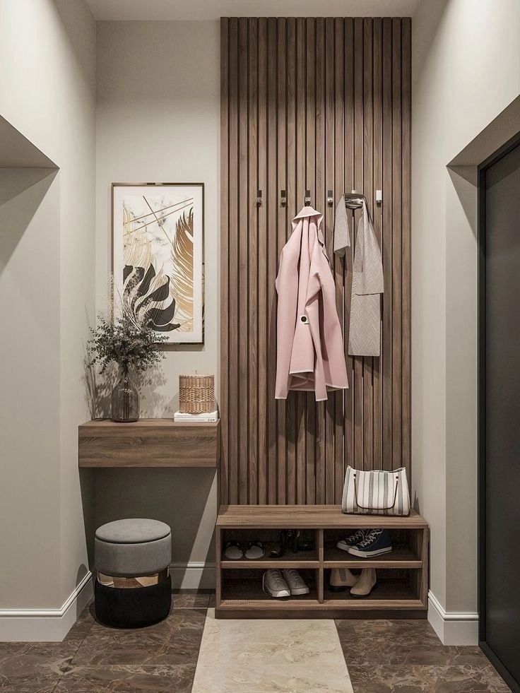 a coat rack with shoes and coats hanging on the wall next to an entryway