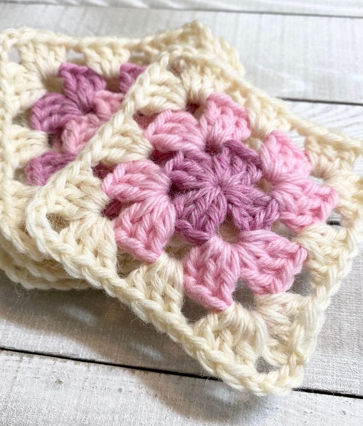 two crocheted coasters sitting on top of a wooden table