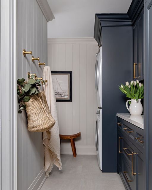 a hallway with blue cabinets and white walls, gold handles on the door knobs