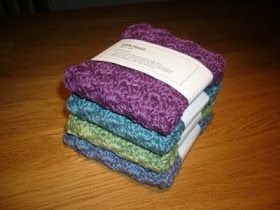 four different colored towels stacked on top of each other in front of a wooden table