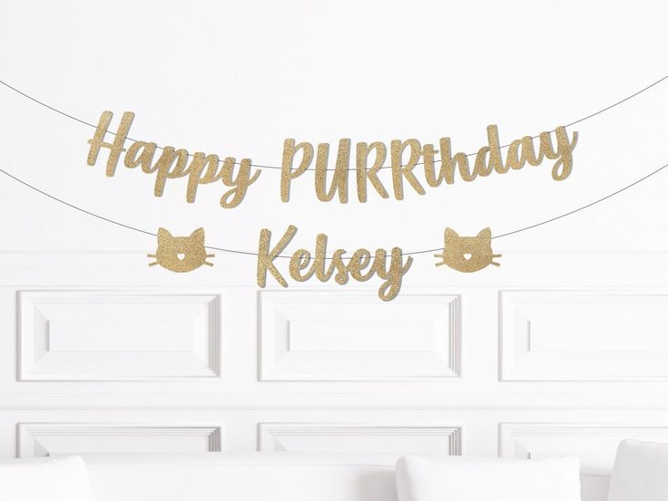 a happy purrritday banner hanging from a string on a bed room wall