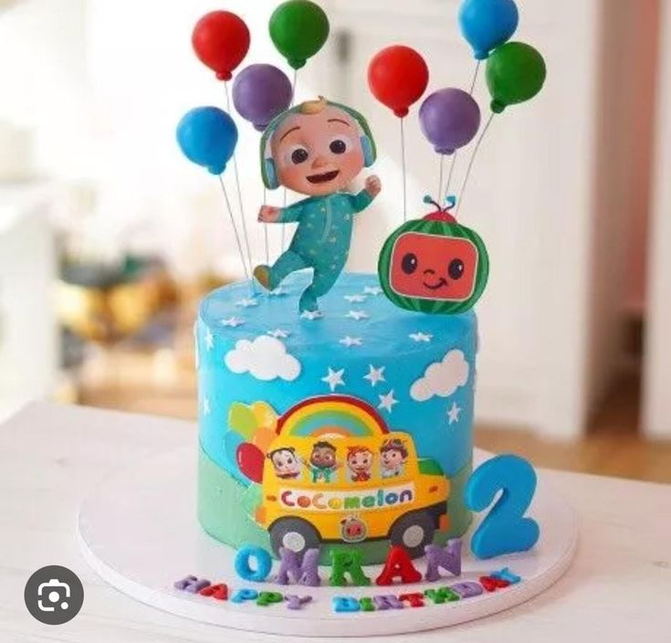 a birthday cake with balloons and a character on top