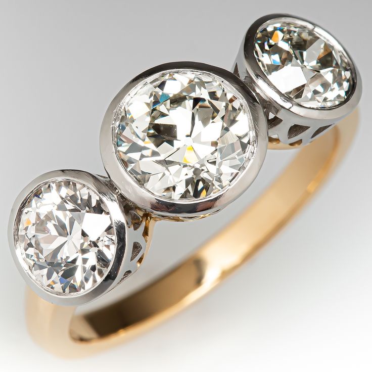 This smooth three-stone style ring is accented with three (3) old European cut diamonds set into platinum bezels. The ring is finished with an 18K yellow gold shank and under gallery. The ring measures 8.0mm at the top, rises 4.7mm above the finger, tapering to 2.3mm wide and 1.5mm thick at the base of the shank. The ring is currently size 6. Antique Cocktail Ring, Bezel Set Diamond Ring, Three Stone Diamond Rings Engagement, Antique Jewellery Designs, Three Stone Diamond Ring, Antique Diamond Rings, Three Stone Diamond, Bezel Set Diamond, Antique Engagement Rings