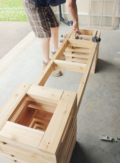 a man is working on some wood in the process of being made into a bench