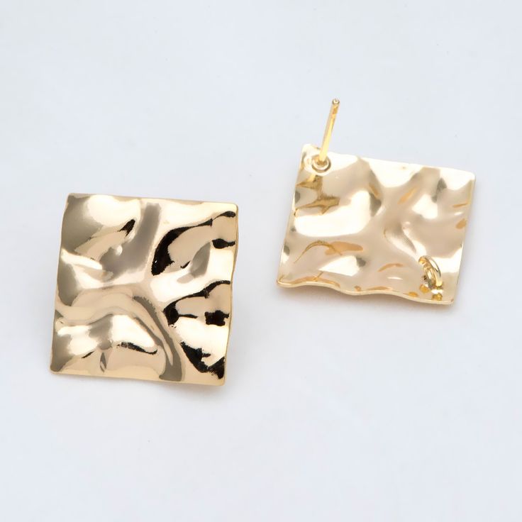 two square shaped gold earrings on a white background, one is made out of metal