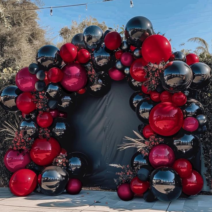 a red and black balloon arch with lots of balloons