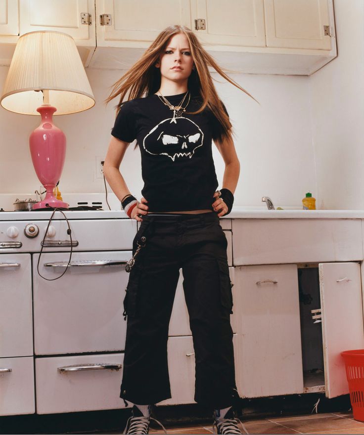 a woman standing in the middle of a kitchen with her hair blowing in the wind