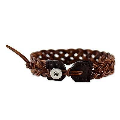 a brown leather bracelet with two metal clasps and a button on the clasp is shown