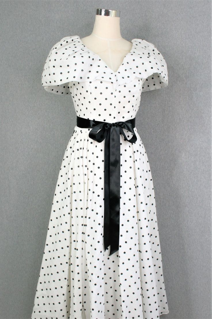 "This dress is commercially made, but without tags.  It is fully lined and in the collar there is a light nettins to give and hold it's shape.   The skirt is three layers; a cotton blend organza, a polyester sheer layer , and acetate or rayon lining.  It is without holes or stains, but the original belt or sash is missing.   We have shown it with a couple of ribbons at the waist just to ispire styling.   They are not included.  Estimated size 12 38\" bust 30\" waist full hip 17\" shoulder to waist 50\" shoulder to hem  34\" waist to hem  Purveyor's Note: We have searched far and wide, wrestled bears, braved the cold, traversed mountain ranges, fought pirates, swam with sharks and eaten at many a questionable road side taco stand to provide our customers with one of a kind vintage pieces. Polka Dot Midi Dress For Summer Formal, Formal Polka Dot Midi Dress For Summer, Polka Dot Midi Dress For Formal Occasions, Formal Polka Dot Midi Dress, V-neck Polka Dot Dress For Formal Occasions, Polka Dot Short Sleeve Formal Dress, Formal Short Sleeve Polka Dot Dress, Polka Dot Short Sleeve Evening Dress, Polka Dot A-line Lined Dress