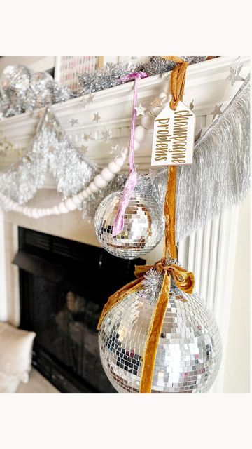 two disco ball ornaments hanging from a mantel in front of a fire place and fireplace