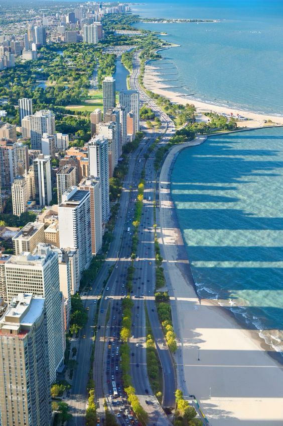 an aerial view of the beach and ocean in chicago, illinois on a sunny day