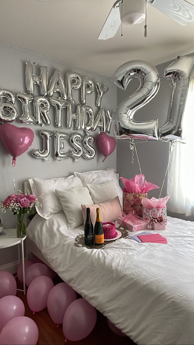 a bedroom decorated with balloons and pink flowers