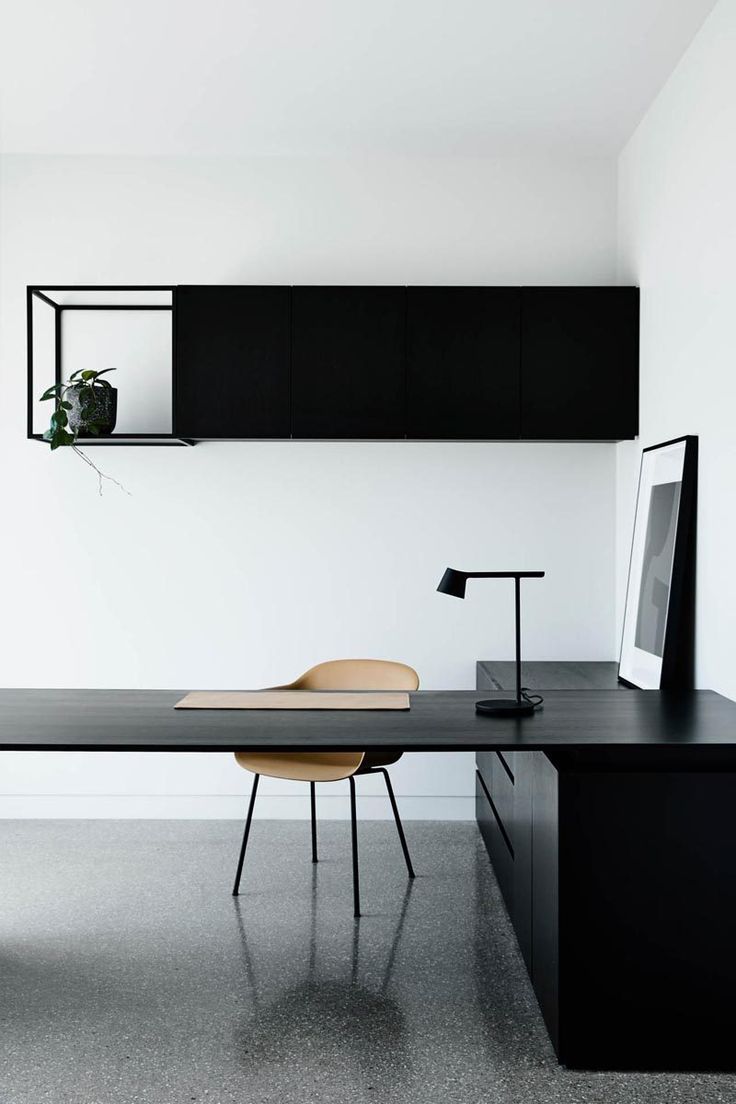 a black desk with a chair and shelf above it