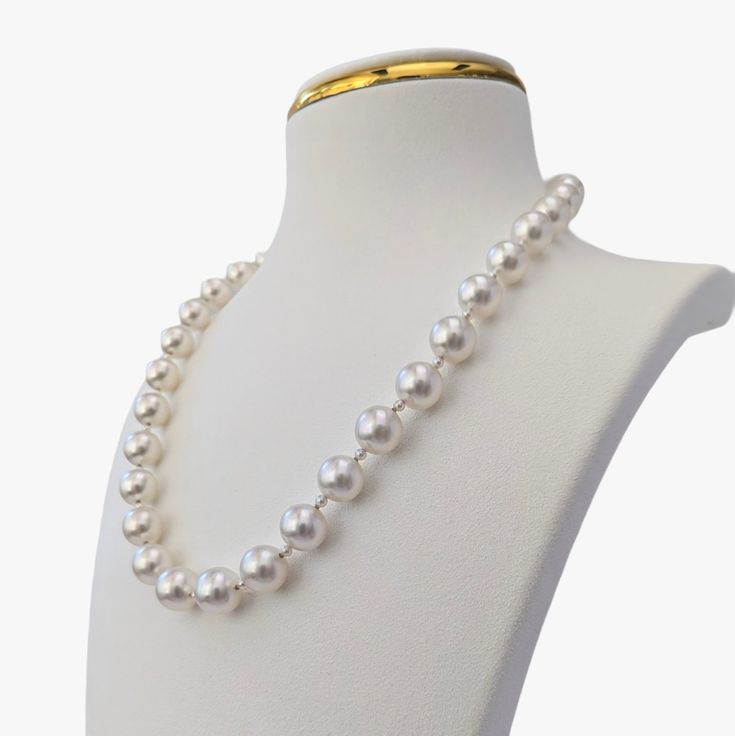 This necklace radiates elegance and sophistication with its magnificent and airy design. It features exquisite Australian White South Sea pearls with a fine luster and clean surfaces with only very minor inclusions. The pearls are round/almost round, ranging in size from 9 to 11mm. They threaded intermittently with 2.5-3.mm baby Akoya pearls, round, with high luster and green and blue obertone. The necklace is secured with a 14K yellow gold clasp that is embellished with 0.11ct diamonds (NC/SI). Formal White High Luster Necklace, Elegant Necklace With Pearl Drop And Round Beads, Timeless Round Pearl Necklace For Formal Occasions, Luxury High Luster White Pearl Necklace, Luxury Akoya Pearl Necklace For Formal Occasions, Luxury White Single Strand Pearl Necklace, Luxury Akoya Pearl Necklace For Formal Events, Timeless White Gold Round Bead Necklaces, Timeless White Gold Necklaces With Round Beads