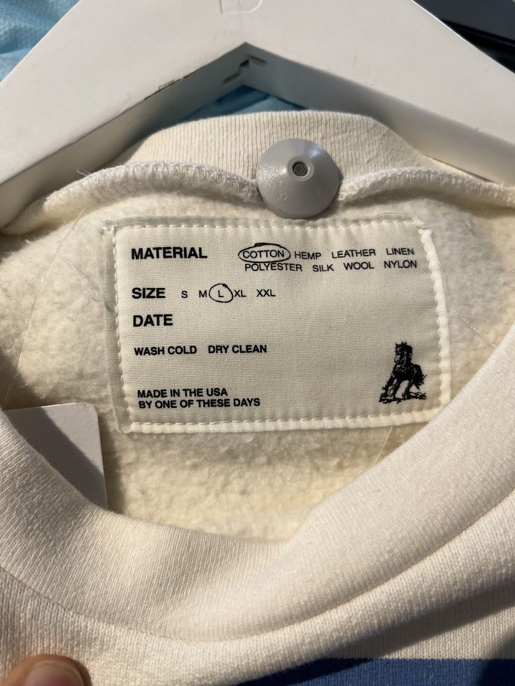 a label on the back of a white t - shirt that says, material date