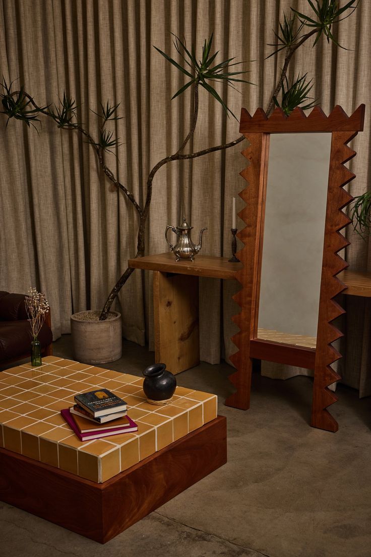 a living room with a table, mirror and plant on the coffee table in front of it