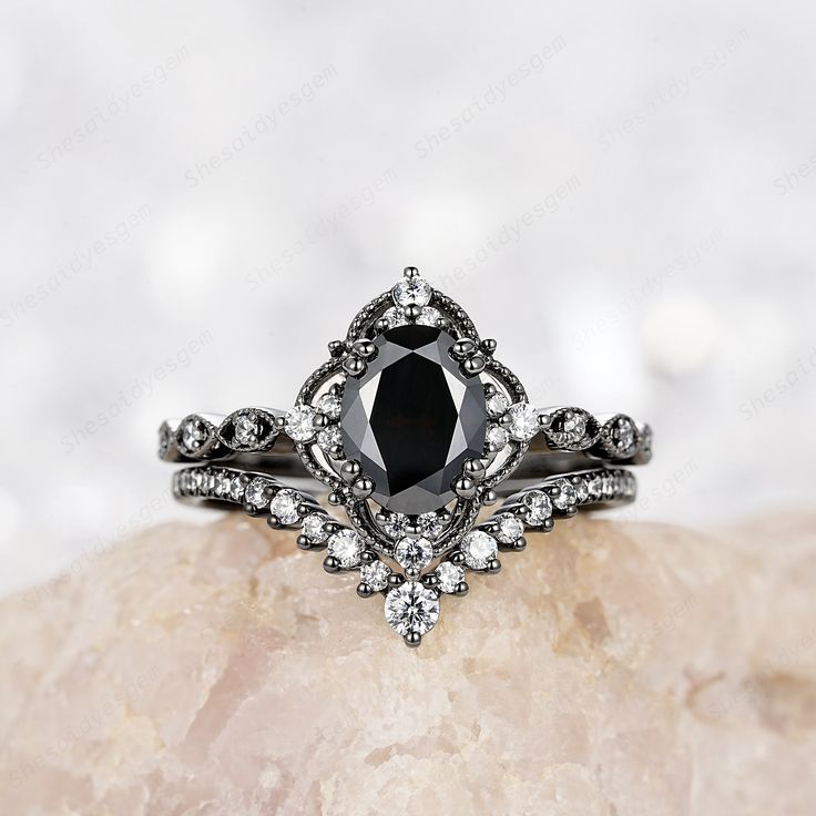 a black diamond ring sitting on top of a rock