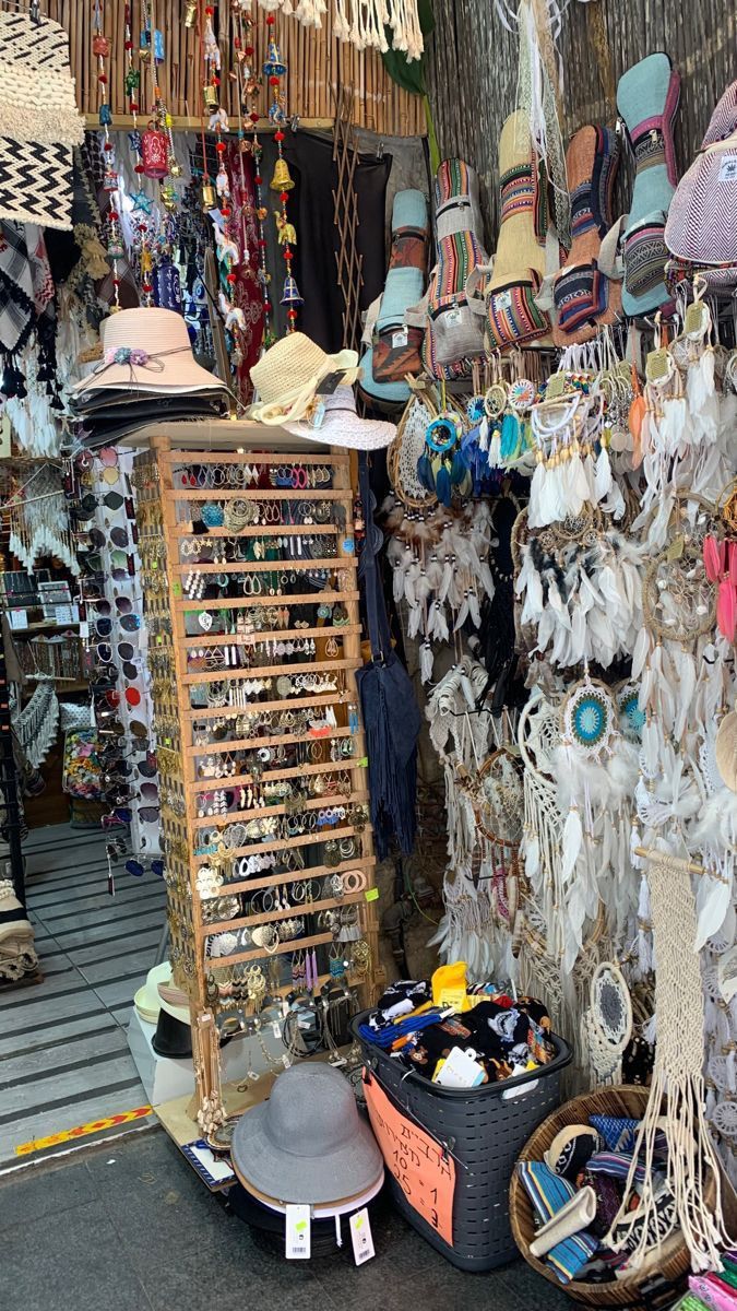 many hats and other items are on display in a storefront with lots of hanging objects