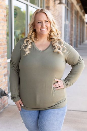 Add sophistication to your everyday attire with the Larissa Long Sleeve Top in olive. This essential V-neck top blends timeless style with modern comfort, making it perfect for any occasion. Crafted from a soft mix of 95% rayon and 5% spandex, it offers a snug yet flexible fit that moves with you. Whether you're dressing up for a night out or keeping it casual for a day in, this top ensures you stay cozy with its long sleeves and relaxed fit. Fabric Composition: Premium blend of 95% rayon and 5% spandex for supreme comfort.Fit: Designed to run true to size for a perfect fit every time.Model Sizing: Tiffanee is effortlessly stylish in a size small, while Lexi looks stunning in 1XL. Casual Olive V-neck Top, Olive V-neck Tops For Spring, Versatile Green V-neck Top, Stay Cozy, Beautiful Eyes, V Neck Tops, Top Trends, Timeless Style, Long Sleeve Top