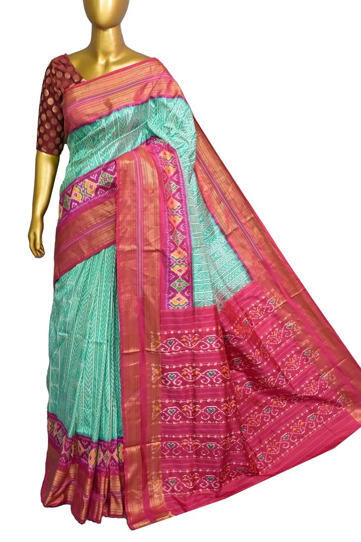 Something new and full of vibe, a sea green and magenta combination of ikat silk. Hand-picked collection with a traditional paisley motif design on the body with ikat weaving work on the pallu which also sports an amazing ikat tribal work with a double border and zari work. Color: A shade of sea green and magenta color Technique: Amazing work of traditional tie and dye work on the whole saree with zari work Fabric: Ikat Silk Quality: IndyVogue's Assurance of Silk Mark Certified Traditional Fitted Turquoise Saree, Fitted Traditional Turquoise Saree, Fitted Turquoise Traditional Wear, Traditional Green Ikat Print Saree, Green Ikat Print Saree, Green Ikat Print Saree In Traditional Drape, Green Ikat Print Traditional Saree, Green Ikat Print Traditional Drape Wear, Green Traditional Wear With Ikat Print Drape