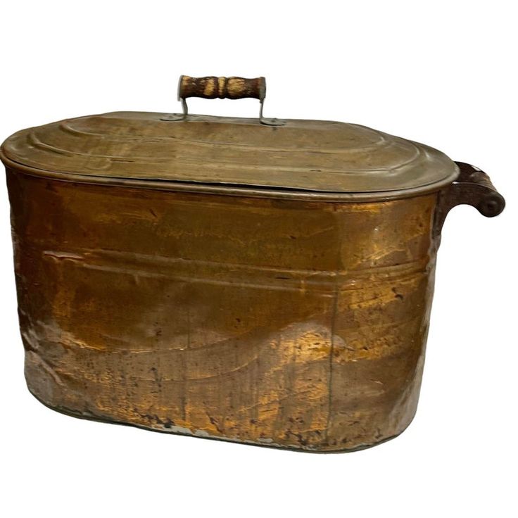 an old metal container with a wooden handle