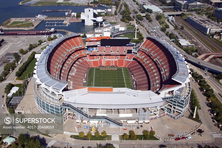 an aerial view of a football stadium with water in the background and buildings around it