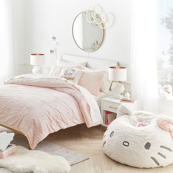 a bedroom decorated in pink and white with a hello kitty comforter on the bed