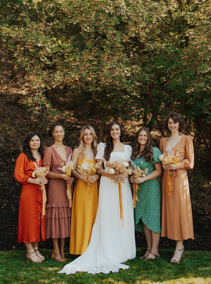 a group of women standing next to each other on top of a lush green field