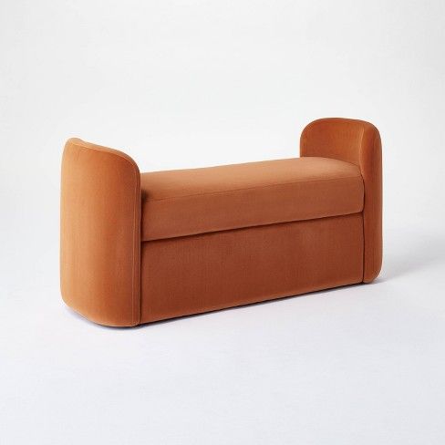 an orange couch sitting on top of a white floor