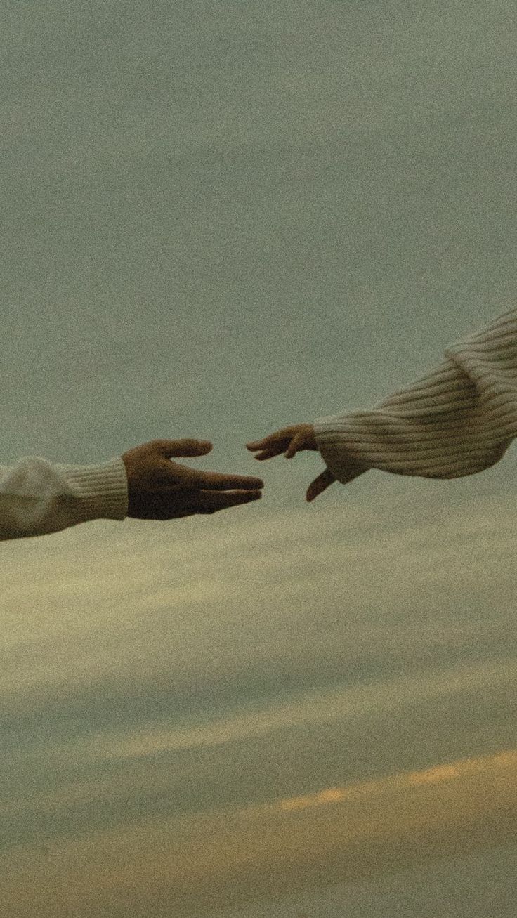 two hands reaching out towards each other in the sky