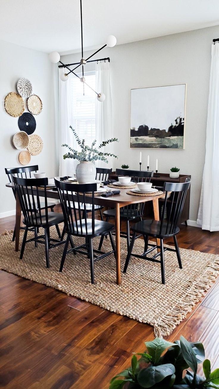 the dining room table is set with black chairs and placemats, along with a potted plant