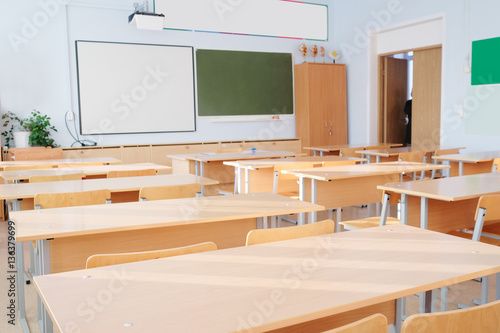 an empty classroom with desks and chalkboards