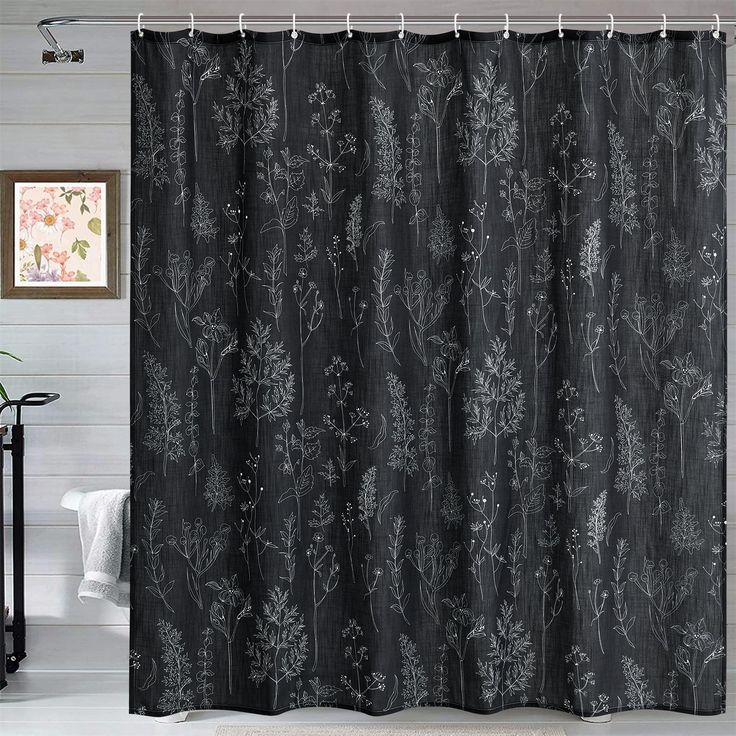 a black shower curtain with white flowers on it