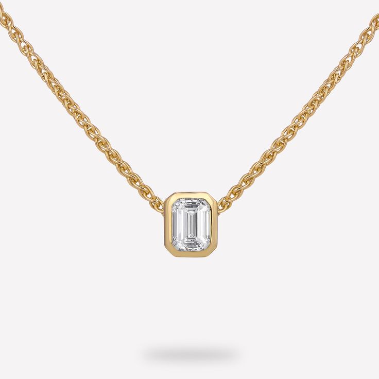 14KT Yellow Gold 1/4 CTW Diamond pendant with chain. The diamond emerald bezel slide pendant is a luxurious and striking piece of jewelry that perfectly balances timeless elegance with contemporary flair. The pendant features a bezel-set emerald cut diamond, and comes with a thin and elegant wheat chain. Its design allows the beauty of the emerald cut diamond to take center stage, while still adding a touch of contemporary flair and versatility. Material : 14KT Gold Pendant Dimension : 5.23x4.24 Emerald Cut Diamond, Pendant With Chain, Diamond Chain, Emerald Stone, Emerald Cut Diamonds, Center Stage, 14kt Gold, Diamond Solitaire, Bezel Setting