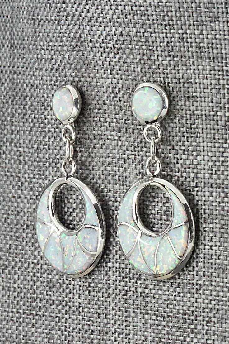 These opalite and sterling silver inlay earrings were made by Zuni silversmith Delorna Lahi. The backs are signed DL.Length: 1 1/2"Width: 3/4"Free shipping on all orders! We ship with USPS and always include tracking. All orders ship within a day of payment.Returns are accepted up to 30 days after you receive your order. Just send us a message. Our shop offers cash back or store credit. The item must be returned in new condition. White Opal Earrings For Pierced Ears, White Elegant Jewelry With Inlay, Elegant White Inlay Jewelry, White Stamped 925 Dangle Jewelry, White Opal Drop Earrings, White Opal Jewelry With Matching Earrings, Silver Inlay Earrings, Silver Inlay Round Earrings, Silver Opal Dangle Jewelry