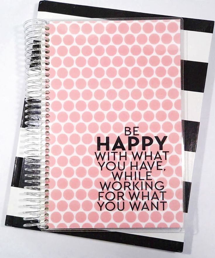 a spiral notebook with the words be happy written in black and white on top of it