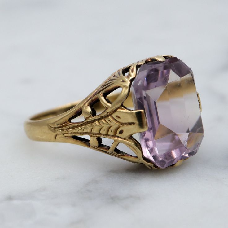 This one of a kind Art Deco period ring by Ostby Barton features an emerald cut natural Rose de France amethyst gemstone, low set into a 14k gold filigree setting with intricate web style engraved shoulders. This ring is a size 5.5, weighs 2.2 grams and the head measures 11mm wide. It is in good antique condition with surface wear to the stone and is marked as shown. Art Deco Oval Amethyst Ring, Gold Oval Amethyst Ring In Art Deco Style, Elegant Rectangular Amethyst Ring For Formal Occasions, Elegant Oval Crafted Jewelry, Elegant Octagon Amethyst Ring For Formal Occasions, Elegant 14k Gold Rectangular Amethyst Ring, Art Deco Amethyst Ring In Yellow Gold, Yellow Gold Amethyst Ring In Art Deco Style, 14k Gold Art Deco Amethyst Ring