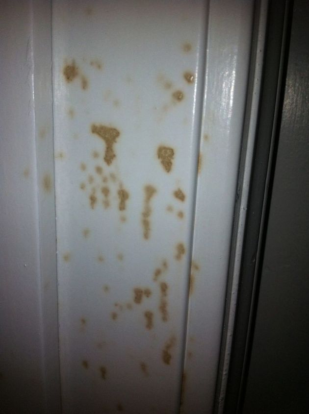 rusted paint on the side of a door in a room that is white and brown