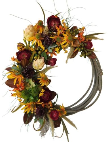 a wreath with flowers and feathers on it