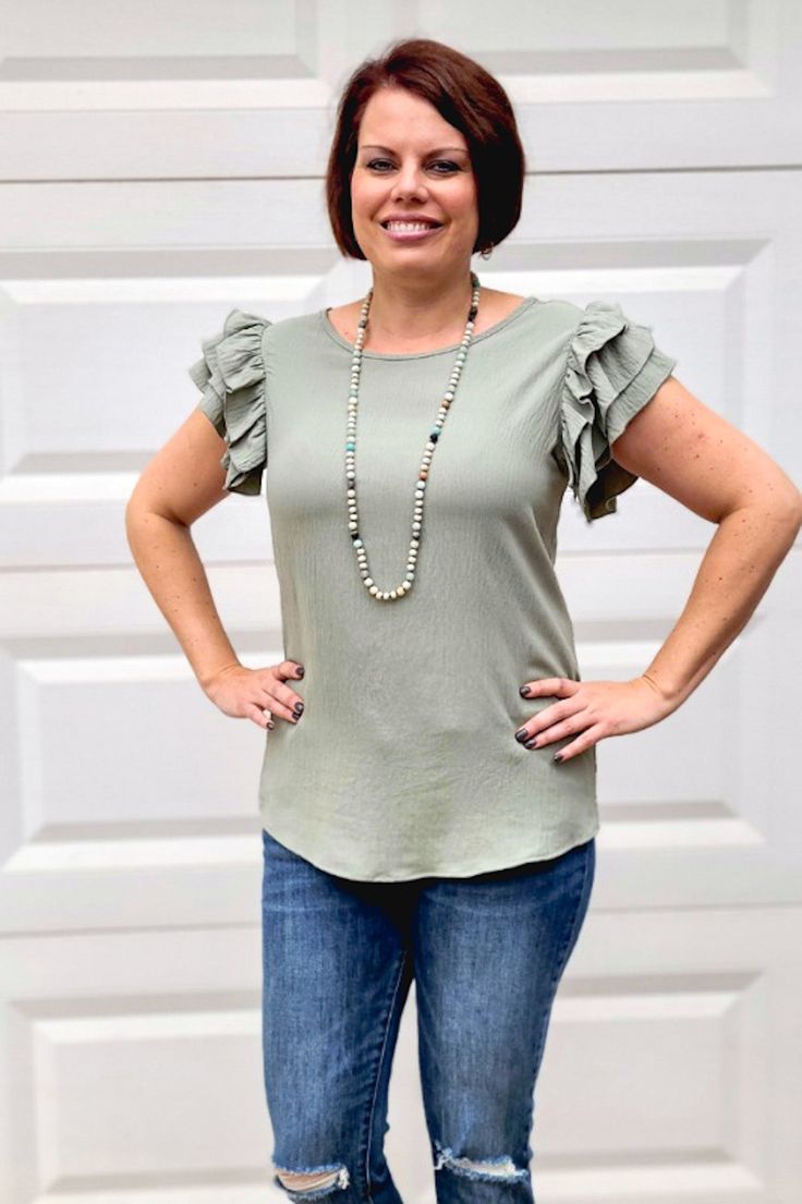 The color of this blouse is gorgeous and screams spring and summer! It also features a round neck, and a button on the back. The flared ruffled sleeves make it so flirty and fun and can so easily be paired with a pair of your favorite shorts or jeans for an easy yet head turning look. ABOUT THIS ITEM: Made in USA. Fabric is 100% Polyester. Hand wash in cold. Hang or line dry. The model is 5'6, and wearing a large. It runs a tad small, so may need to size up. Trendy Flutter Sleeve Top For Summer, Trendy Summer Short Sleeve Top With Flutter Sleeves, Trendy Short Sleeve Top With Flutter Sleeve For Summer, Summer Crew Neck Blouse With Ruffle Hem, Spring Blouse With Ruffle Hem And Crew Neck, Trendy Summer Short Sleeve Top With Ruffles, Trendy Summer Blouse With Flutter Sleeves, Trendy Tops With Flutter Sleeve And Ruffle Hem, Chic Crew Neck Blouse For Brunch