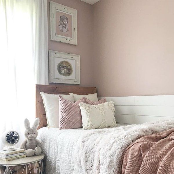 a bedroom with pink walls and white bedding