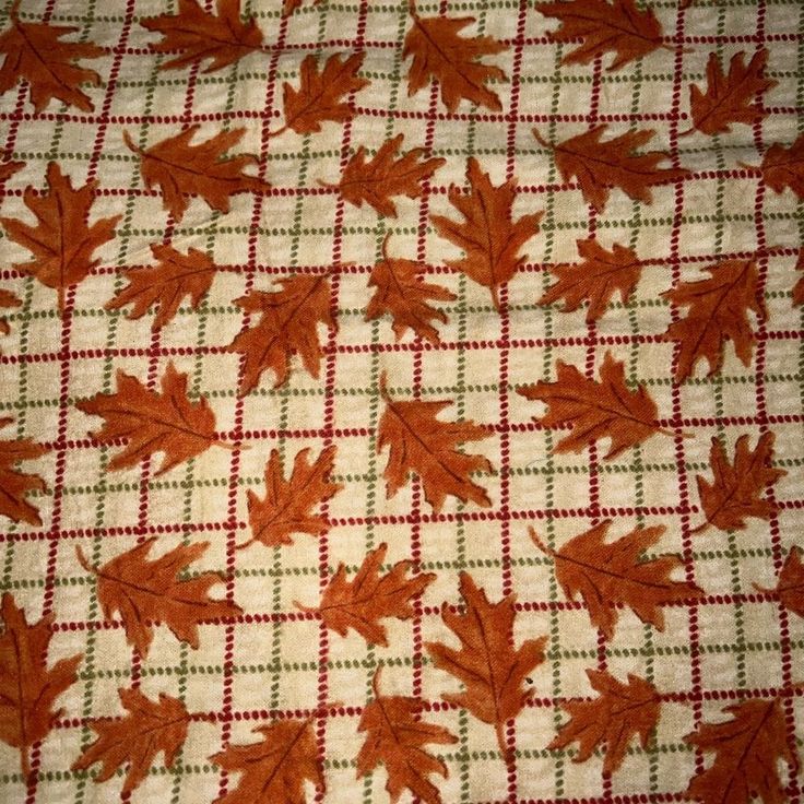 an orange and white checkered table cloth with leaves on it