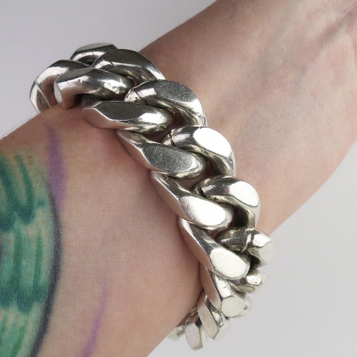 Super thick sturdy heavy sterling links flow around this vintage Mexican bracelet. The bracelet is constructed with 15/16 inch x 3/4 inch links that have a 9.2mm (3/8 inch) thickness. The heavy links have flat edges and conform to the wrist nicely. The bracelet closes with a long and wide curved box clasp topped by a push-bar button. The hefty bracelet contains over 200 grams of sterling silver. The 3/4 inch wide bracelet has an inner circumference of approx. 6 1/2 inches. The back is stamped, "Mexico, IA-20" and hallmarked, "925" (sterling silver). The links and hardware also tested as sterling silver purity.  This piece is in wonderful condition for its heavy weight, with expected minor surface wear and patina. Please see photos for condition and below for detailed measurements. Wt: 213. Classic Silver Cuban Link Bracelet With Chunky Chain, Modern Silver Cuban Link Bracelet With Chunky Chain, Classic Silver Chunky Jewelry, Chunky Oval Link Silver Chain Bracelet, Silver Chunky Classic Jewelry, Silver Chunky Oval Link Chain Bracelet, Classic Chunky Silver Jewelry, Modern Silver Chunky Chain Bracelet, Modern Chunky Silver Bracelet