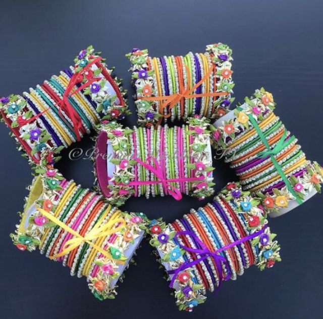 several bracelets are stacked together on top of each other, with ribbons and bows