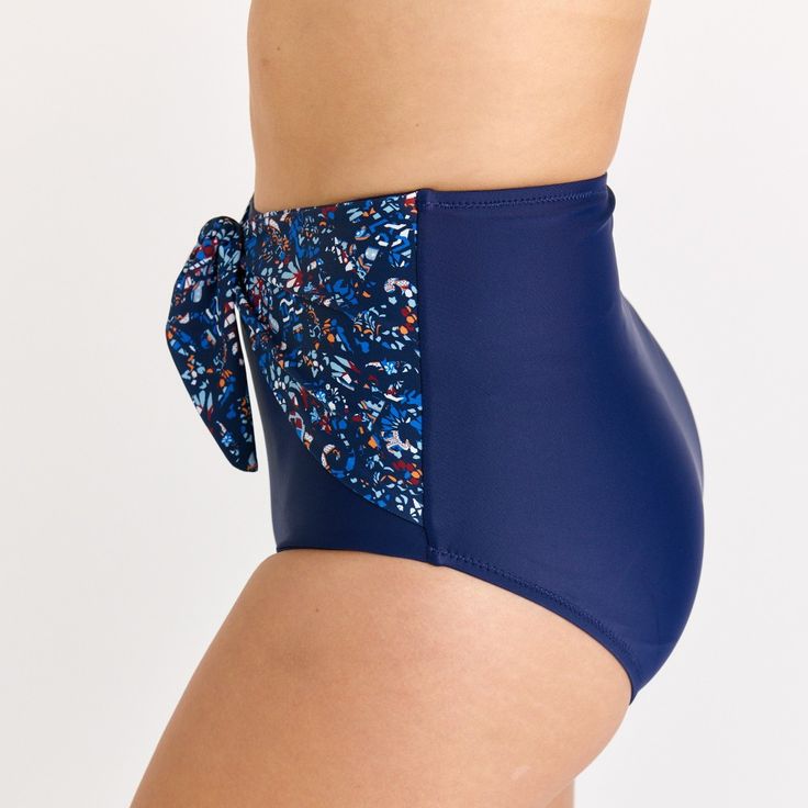 Step up your beach style with our High-Waisted Bikini Bottom featuring a chic front tie detail. Sized to perfection, the hem circumference is 62 cm and the thigh circumference is 49 cm for a Size S. When in doubt, it's best to size up for a comfortable fit. Crafted from 82% nylon and 18% spandex, this fully-lined bikini bottom offers UPF 50+ sun protection and quick-drying capabilities. Sold as a bottom only, you have the freedom to mix and match with your favorite tops. Keep it fresh and vibran Navy Swimwear For Swimming, Navy Fitted Swimwear For Swimming, Fitted Navy Swimwear For Swimming, Blue Tie-side Swim Skirt, Adjustable Blue Tankini For Vacation, Fitted Navy Swimwear For Beach Season, Blue Tie-side Swim Skirt For Sunbathing, Beachy Tankini With Tie-side Bottom For Swimming, Navy Stretch Swimwear For Beach Season