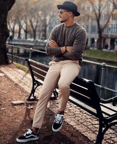 a man is sitting on a bench in the park