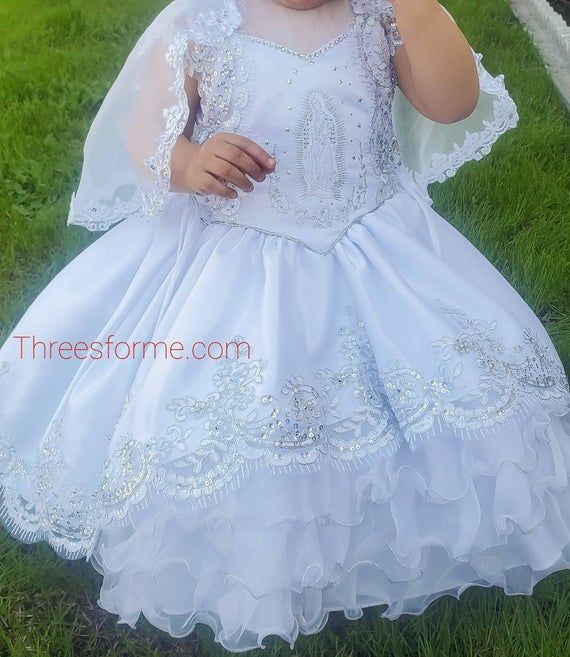 Our Virgin Mary Embroidered Baptism Collection is here!All our dresses are made here in the United States.A 3 pcs dress: includes dress, cape and headband.Our dresses are made of satin, organza and tull.We use satin on our beautiful dresses and organza on capes. Corset on both sides to adjust for perfect fit. A large Virgin Mary Embroidery on chest of dress. Translucent chest top. Dress is high-low cut which means dress has a train on back with beautiful bows. Cape is button attached. fresh for Virgin Mary Embroidery, Mary Embroidery, Bautizo Ideas Girl, Bautizo Ideas, Girls Baptism Dress, Dress Cape, Baptism Ideas, Baptism Gown