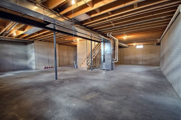 an empty warehouse with exposed ceilings and metal pipes