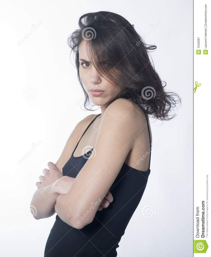 a beautiful young woman in black dress posing with her arms crossed and looking at the camera